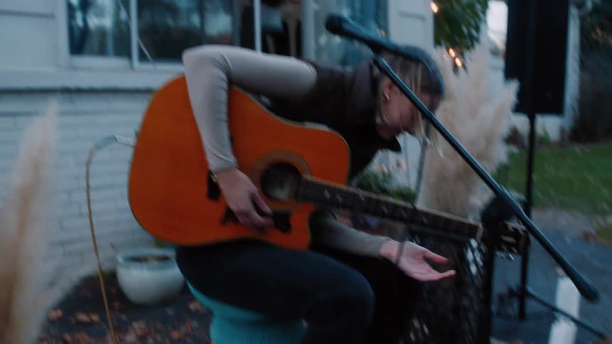 A woman playing guitar in her backyard