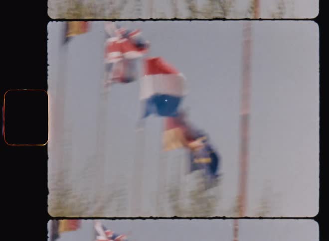 A set of various country flags blowing in the wind on a sunny day