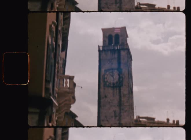 Clock tower towers over row houses on a cloudy day