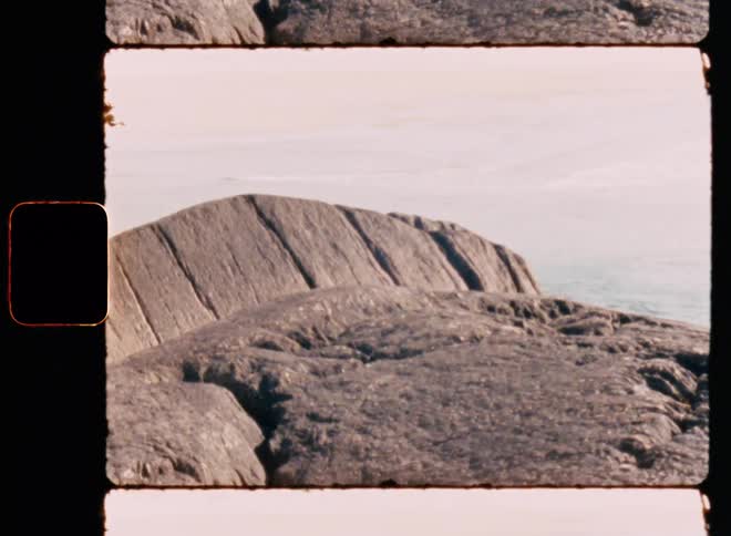 Top of a rocky mountain with the ocean in the background