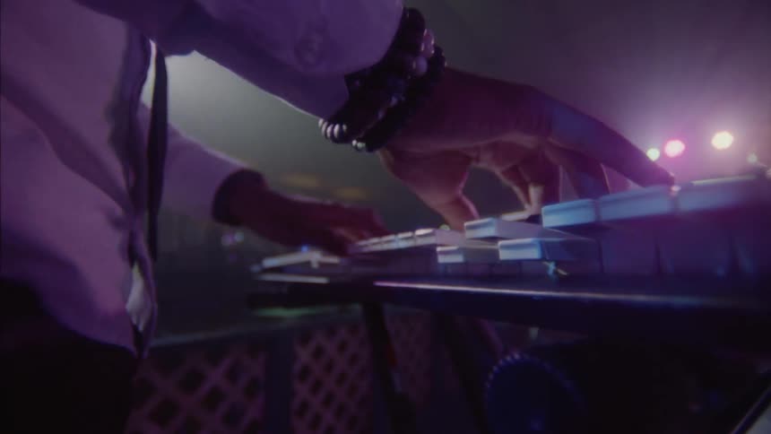 A mans hands skillfully playing a keyboard in a dance club