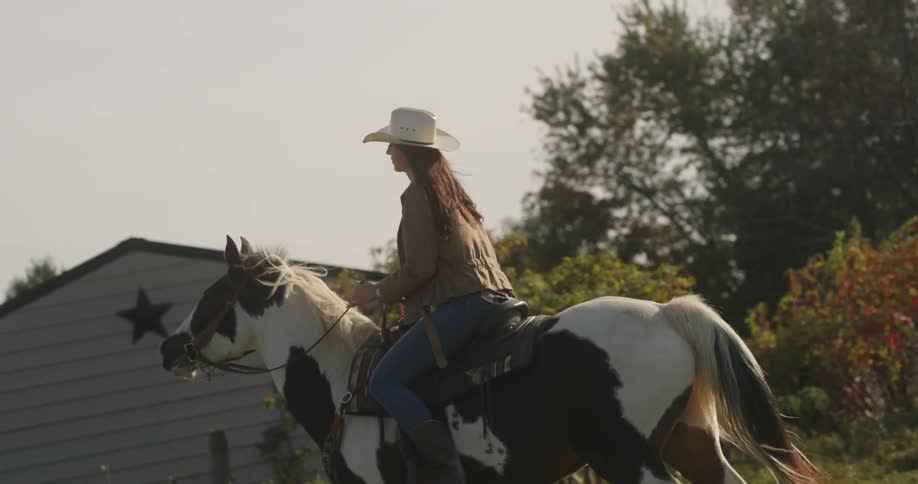 A woman in a cowboy hat riding a horse