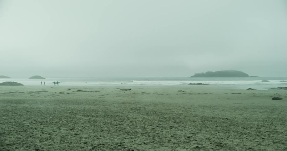 People on a deserted beach on a cloudy day