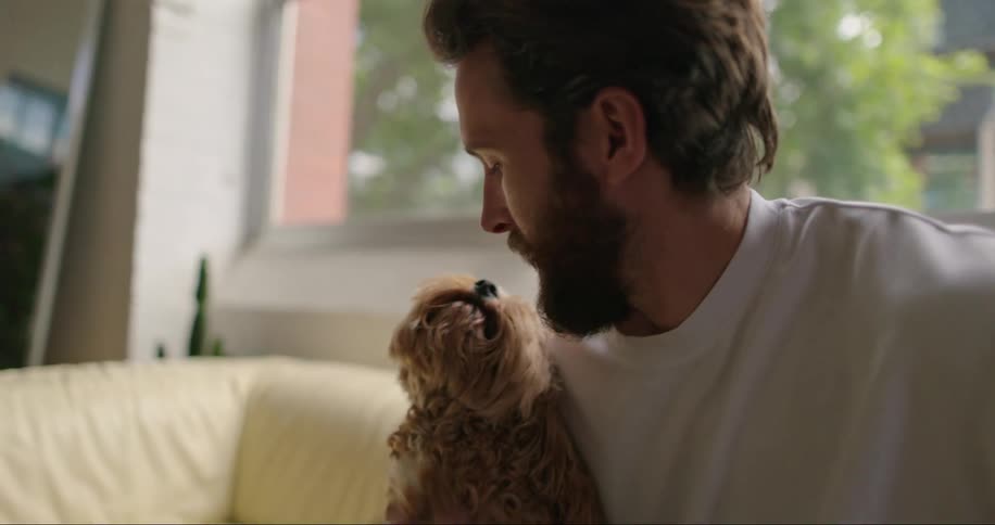 A man kissing and petting a dog