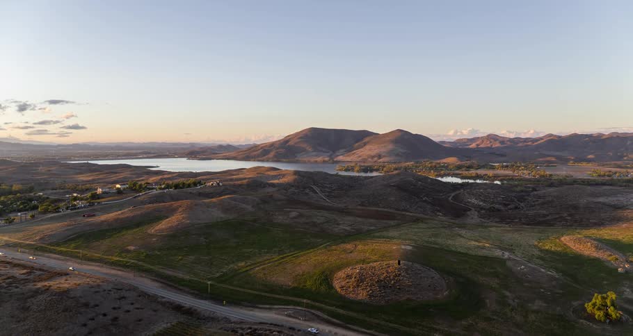 Aerial of a small rural town with a lake and mountains at dawn