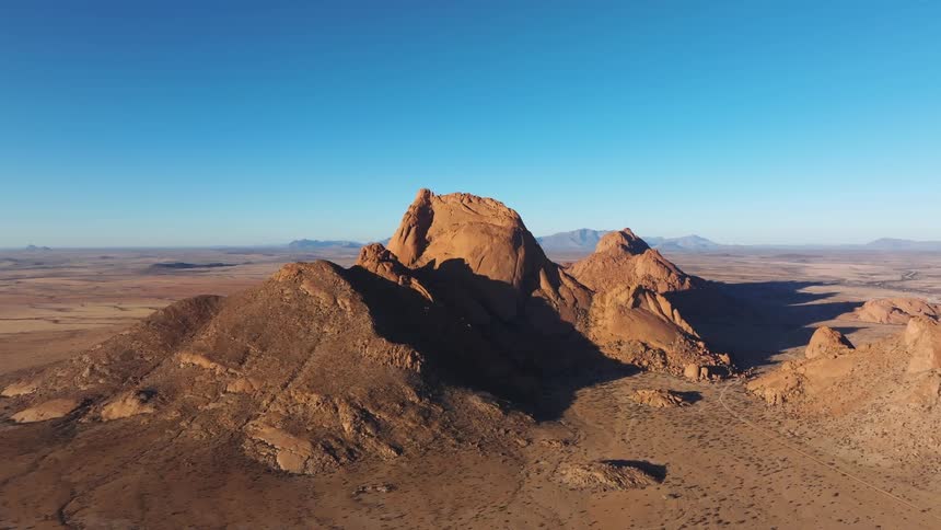 Aerial view of peaks and geological formations in a natural environment under a blue sky