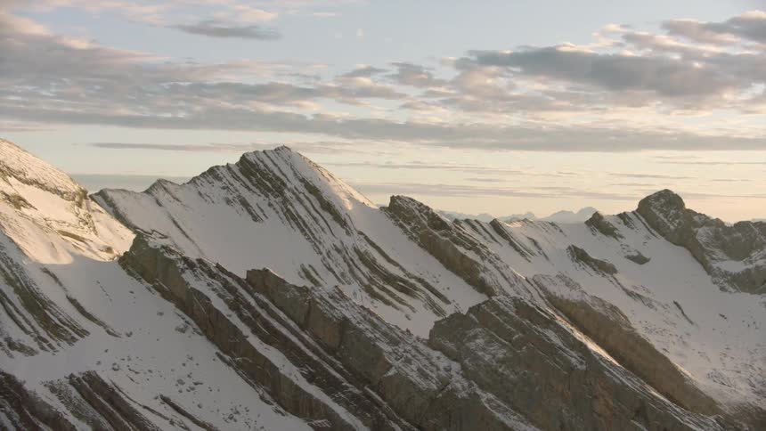 Aerial view of snow in the slopes of a mountain range at morning