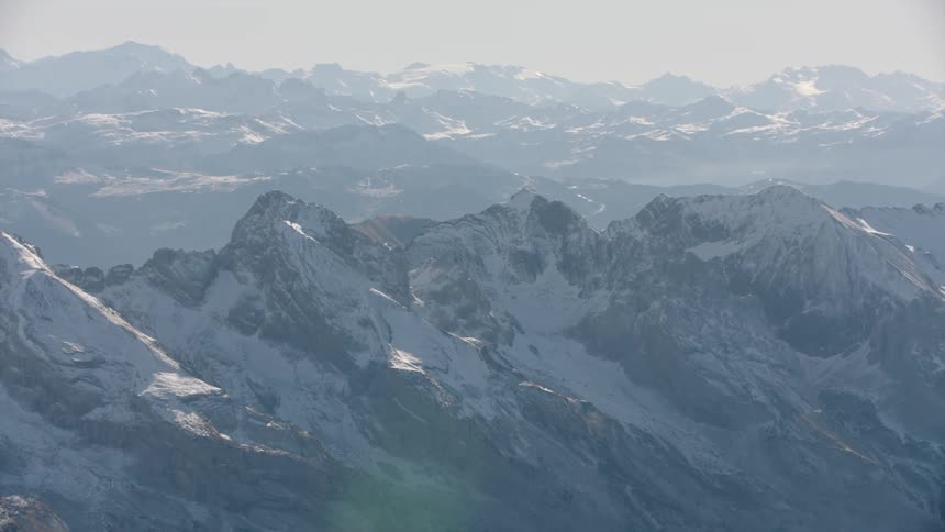 Aerial panorama of mountains and peaks covered in snow during the day