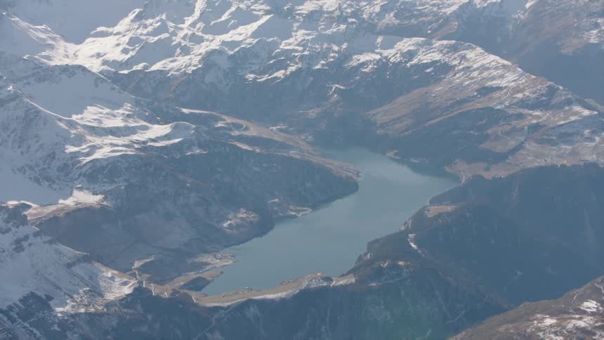 A huge lake on a high mountain in a region with diverse mountains