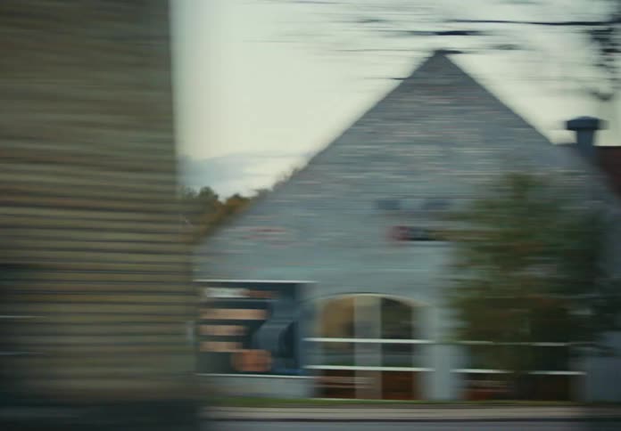 Traveling quickly on a very fast train as it passes by a small city at dusk