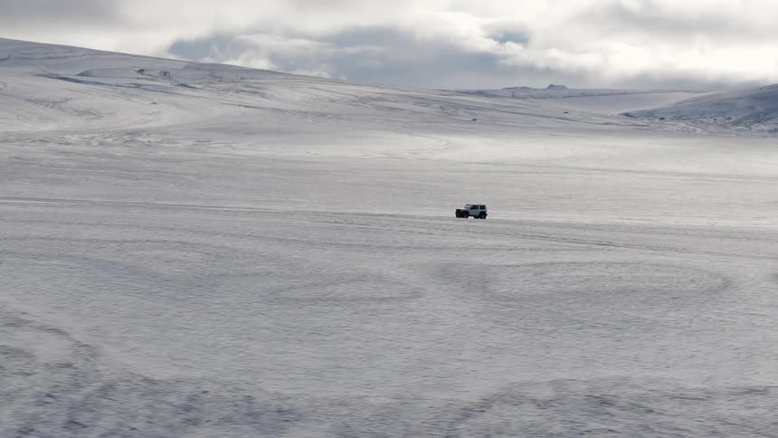 A car driving through the plain with ice and snow in winter
