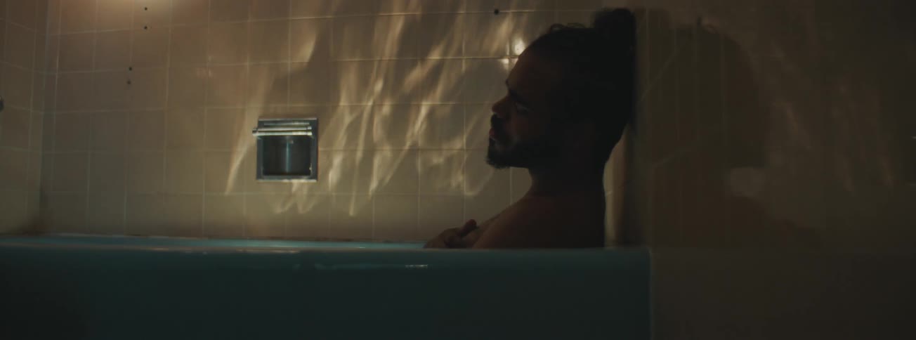 A sad man taking a bath in the bathtub