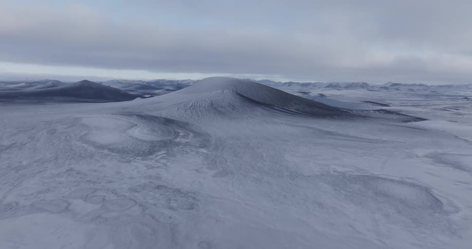 Panorama of plateaus and mountains covered in snow in a gray sky