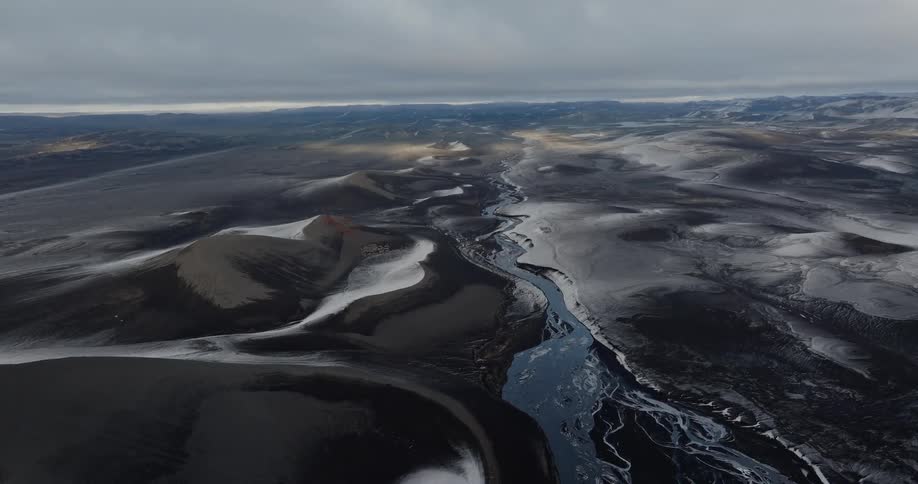 Aerial of plains and hills with frozen lake during winter