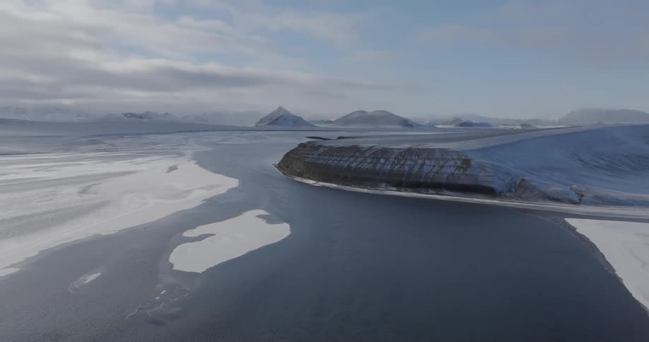 Aerial of a river with mountains and cloudy sky