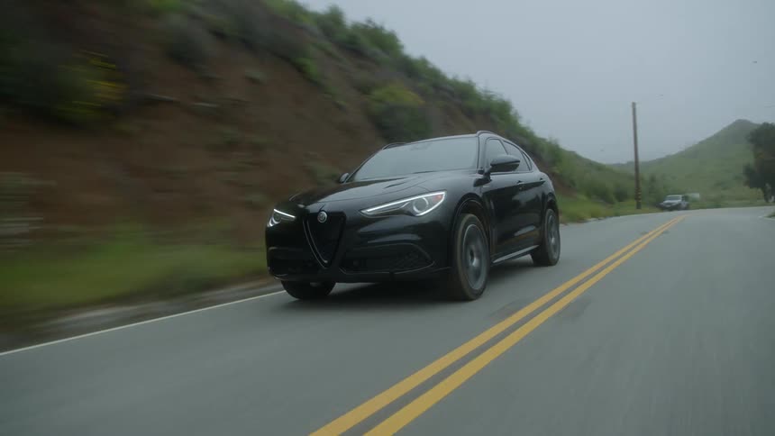 A black car going fast on a road
