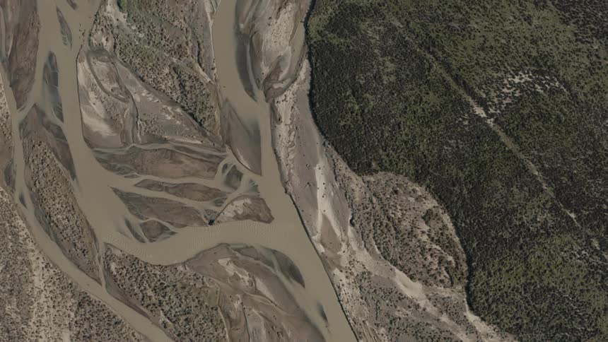A river that is brown and everything around it is covered in mud