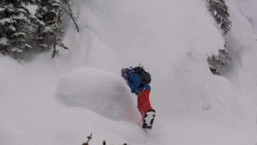 A snowboarder hits a steep powder pillow line