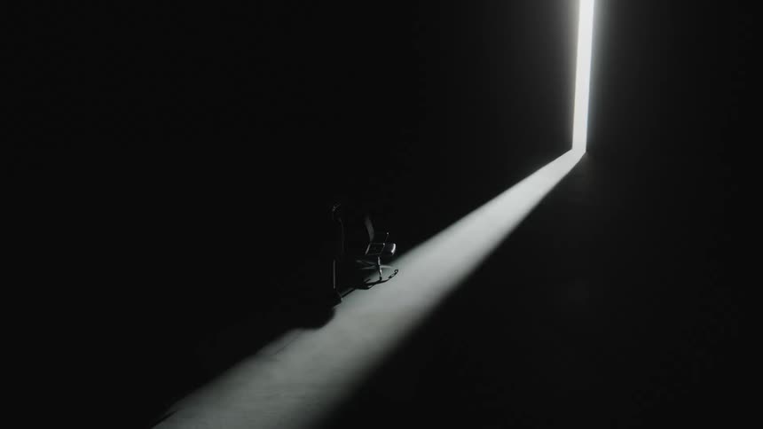A chair in a dark room with the door ajar