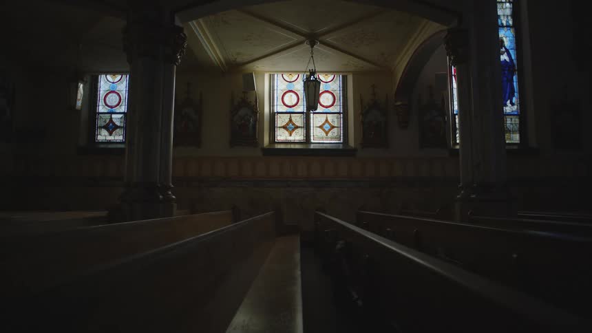 Interior of a catholic church with dark wooden pews
