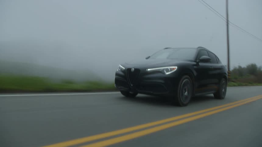 A car speeding on the deserted road in fog