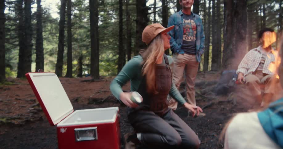 Group of friends have fun aroudn a campfire in the forest