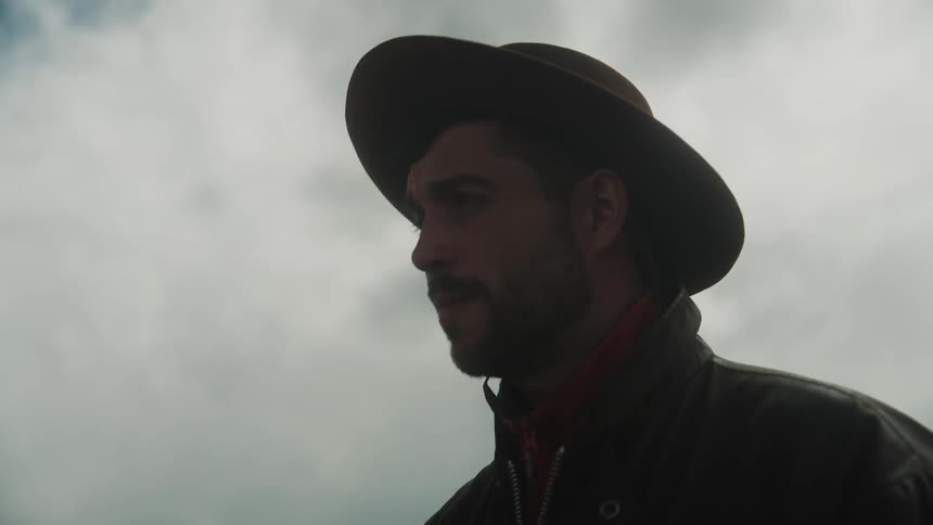A man smokes a cigarette and talks outside