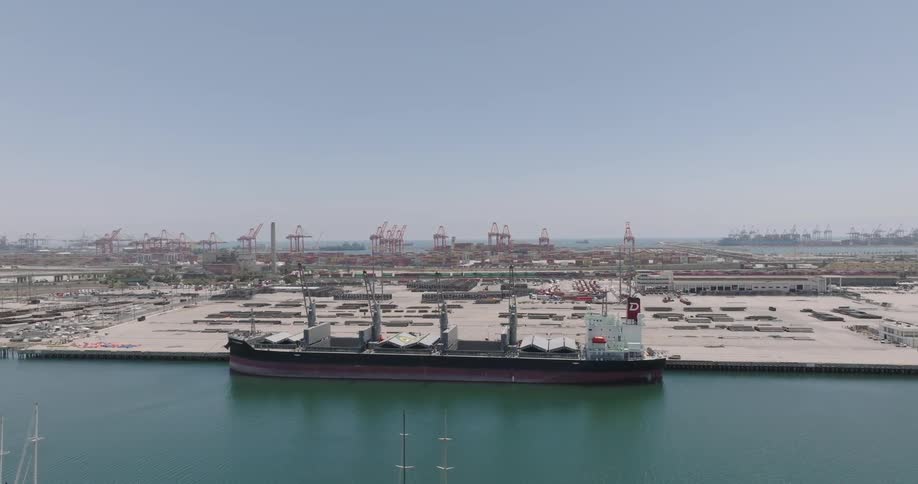 A large ship is docked by the naval base