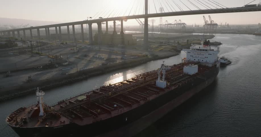 Skyline of a port area with cargo ship sailing at sea