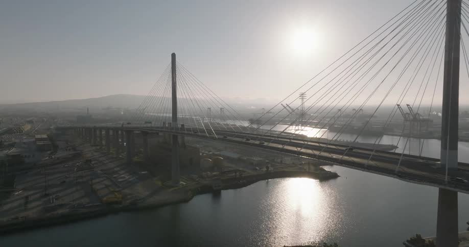 Cars drive over the bridge by the city