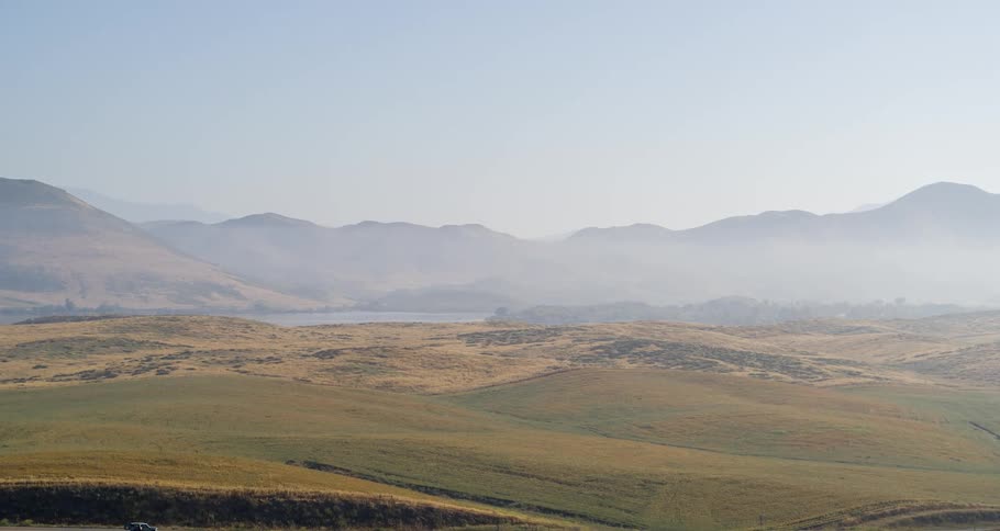 A landscape of a huge lawn and distant mountains in the background