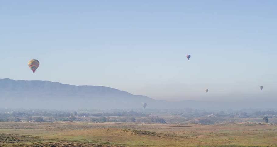 Hot air balloons flying over the countryside during the day