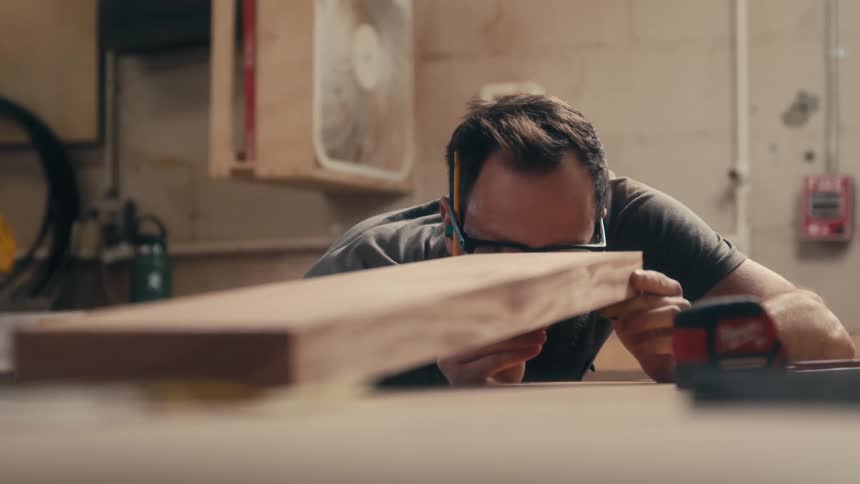 A carpenter in a workshop constructing a furniture
