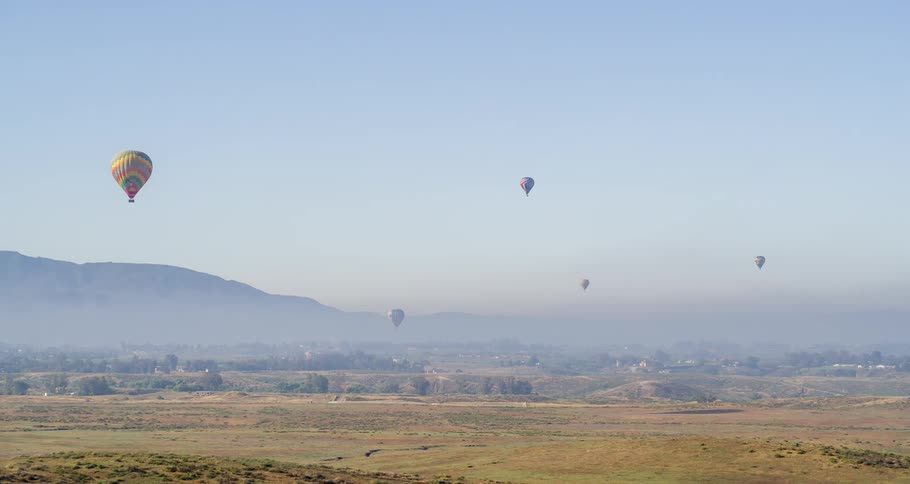 Balloon parachutes in the sky on a sunny day