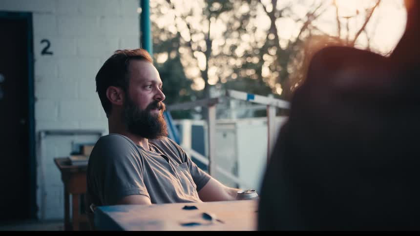 Two men sitting on a balcony and talking