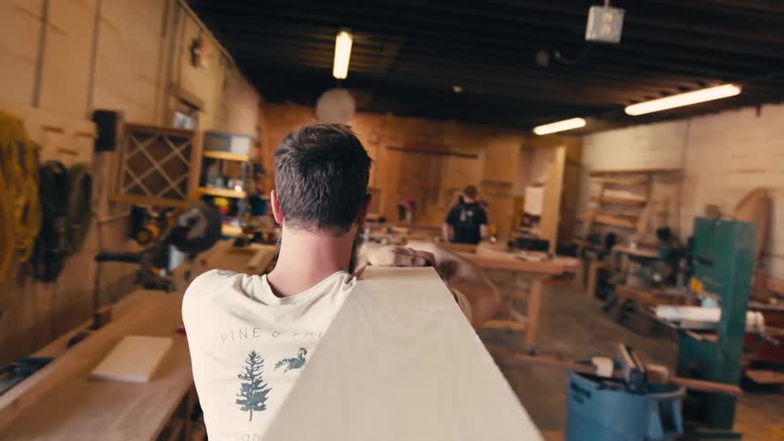 A man is using a saw to cut wood