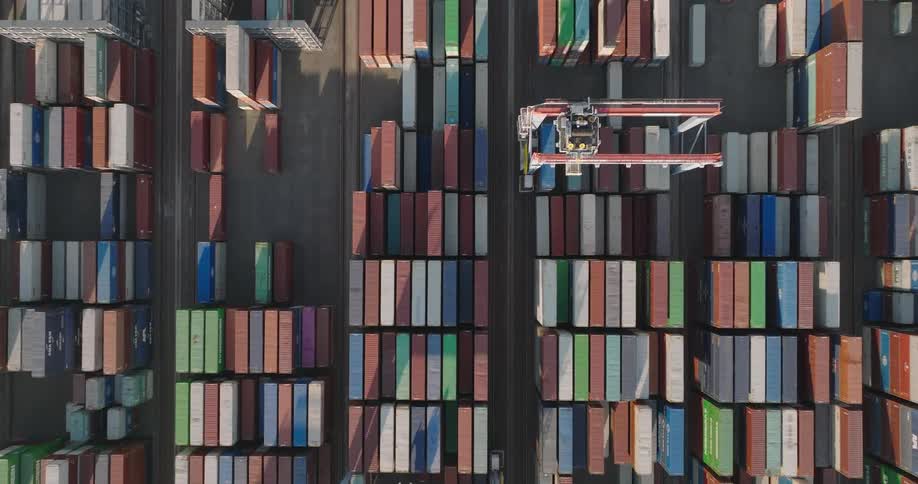 Aerial view of cranes moving containers in a port yard