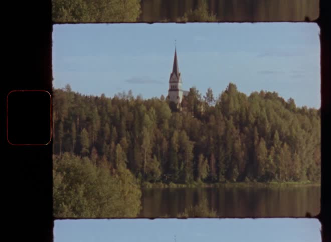 Tower of a manor or church in the forest next to the lake