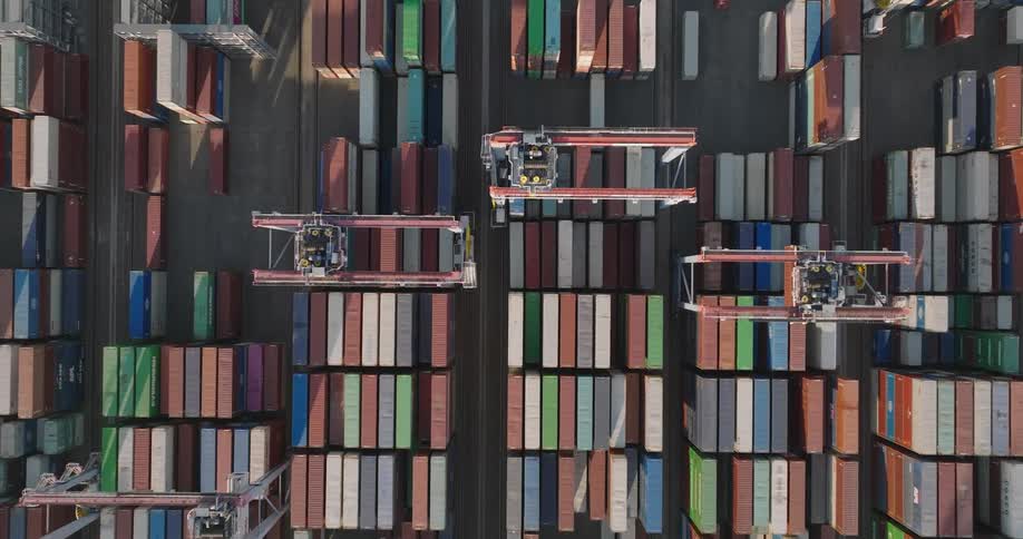 Top view of machines in a logistics center operating beneath containers