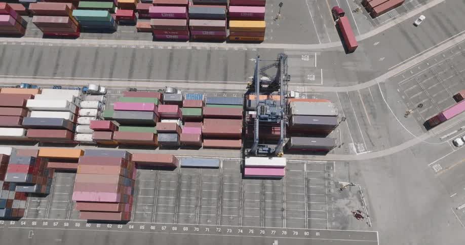 Aerial view of trucks driving out of a container yard next to port
