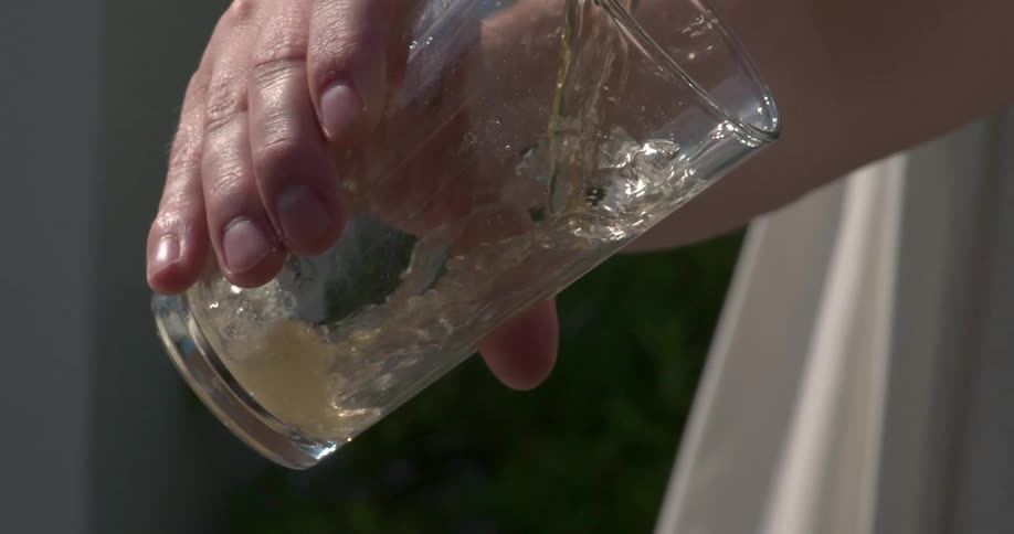 A drink is being poured into a glass