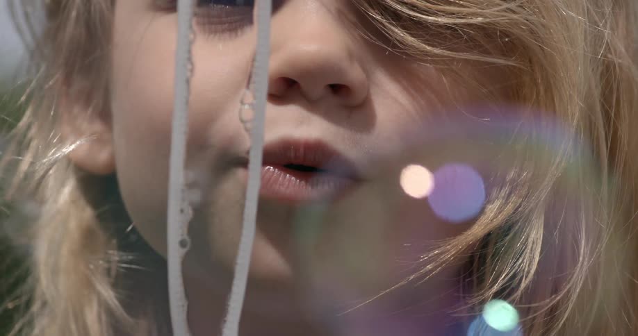 Child blowing bubbles through a wand