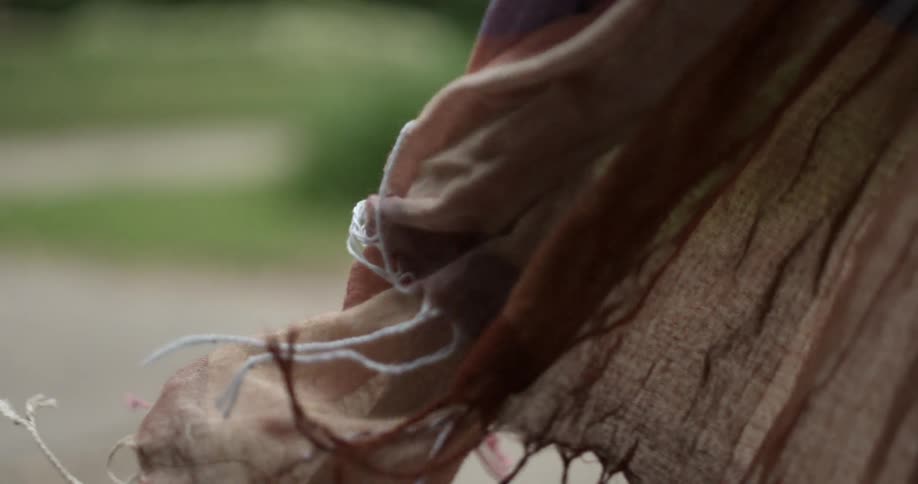 A fringed scarf billows in the wind