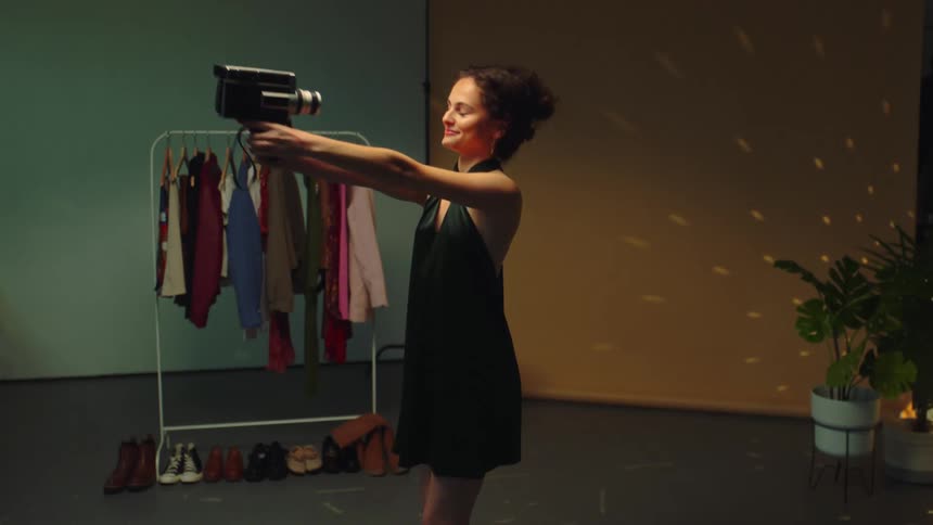 A girl filming herself with a camera while dancing