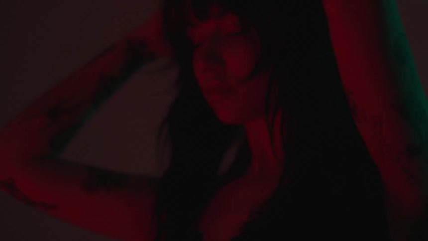 A girl dancing in the dark room with a red light