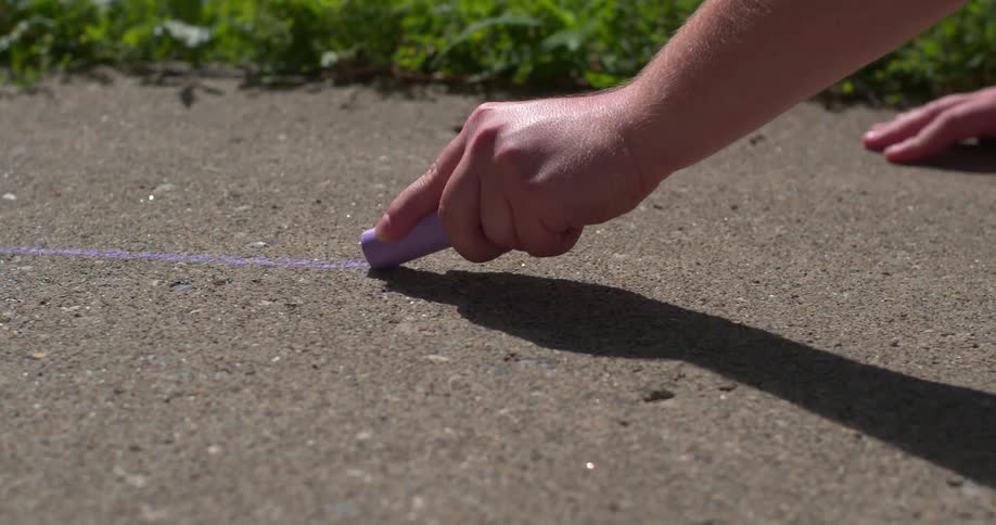 A person is drawing on the ground with chalk