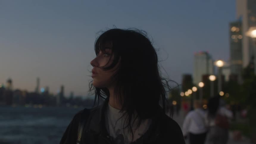 Young woman walks near the river in the city