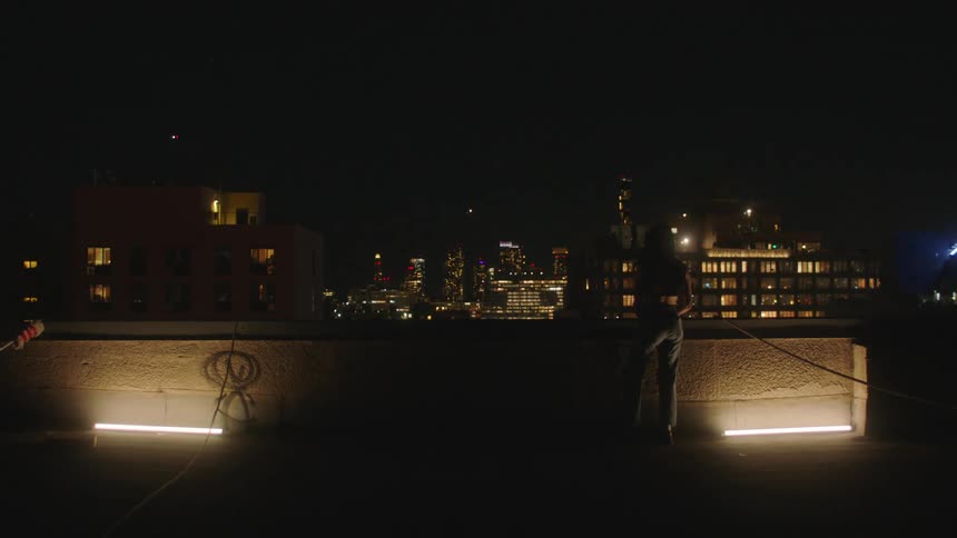 Woman with her back on a terrace at night in a metropolis