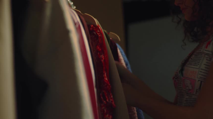 A young woman going through a coat rack