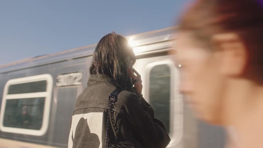 A woman at the train station waiting for the train to stop